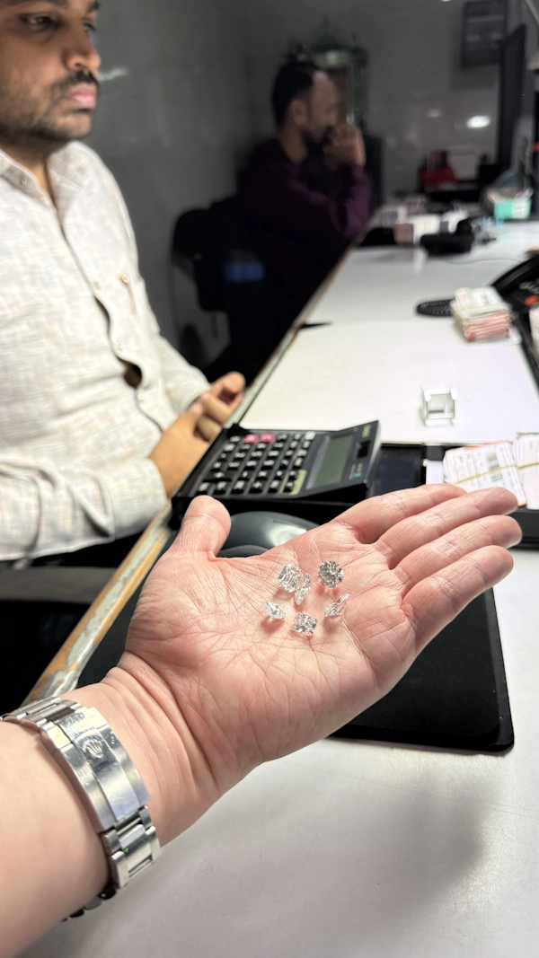 A mixed selection of cut diamonds in hand.