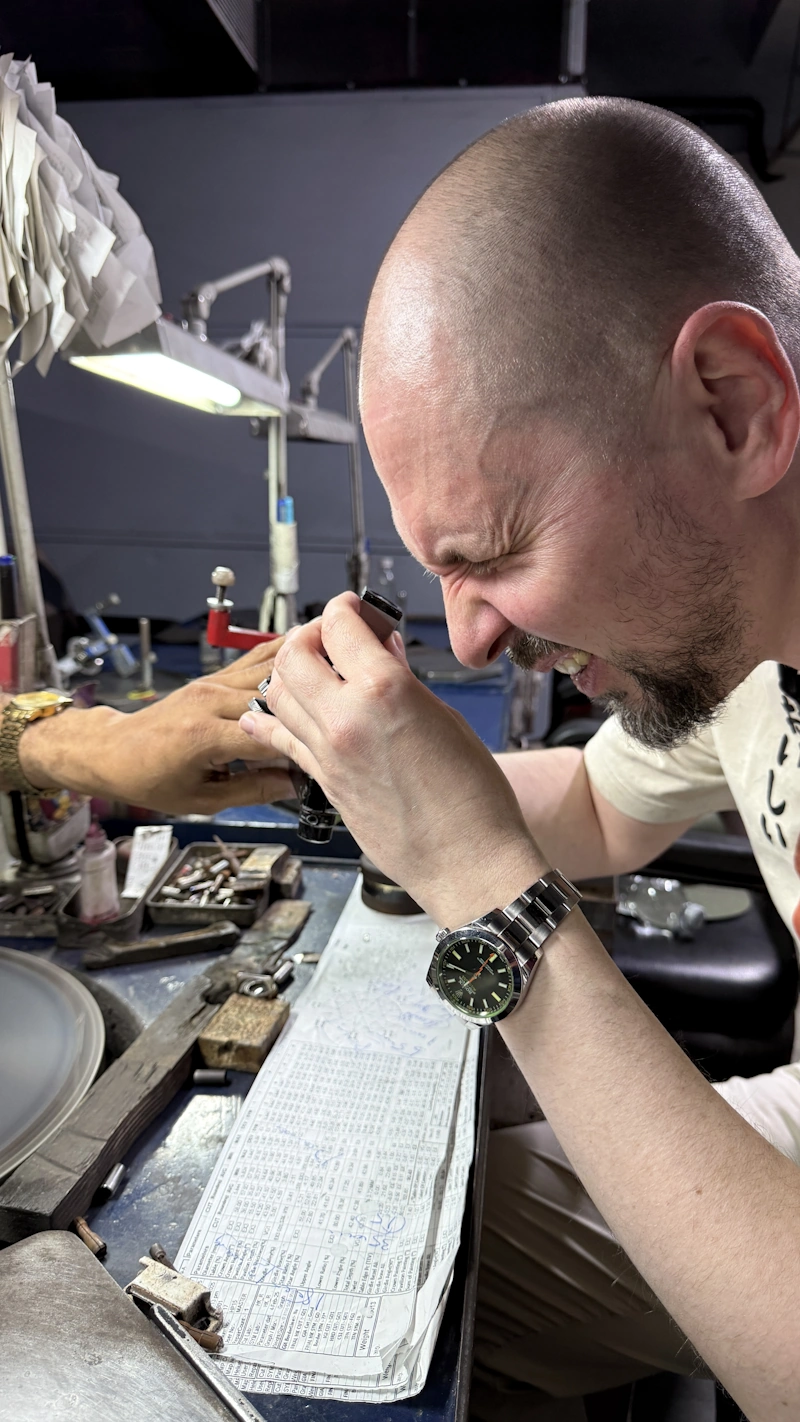 Slava Kravtchenko examining a diamond through a loupe at a partner workshop.